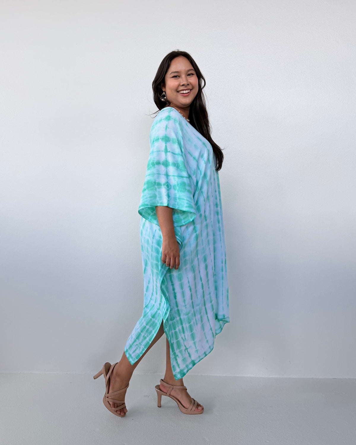 Woman wearing a light blue and white striped dress against a white background