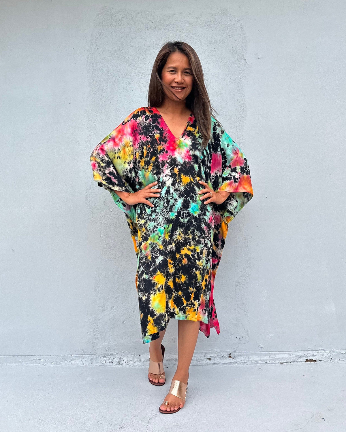 Woman wearing a colorful dress against a white wall