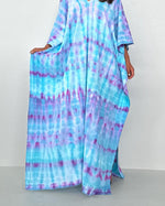Woman wearing a tie-dye dress against a white background