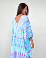 Woman wearing a tie-dye dress with a white background