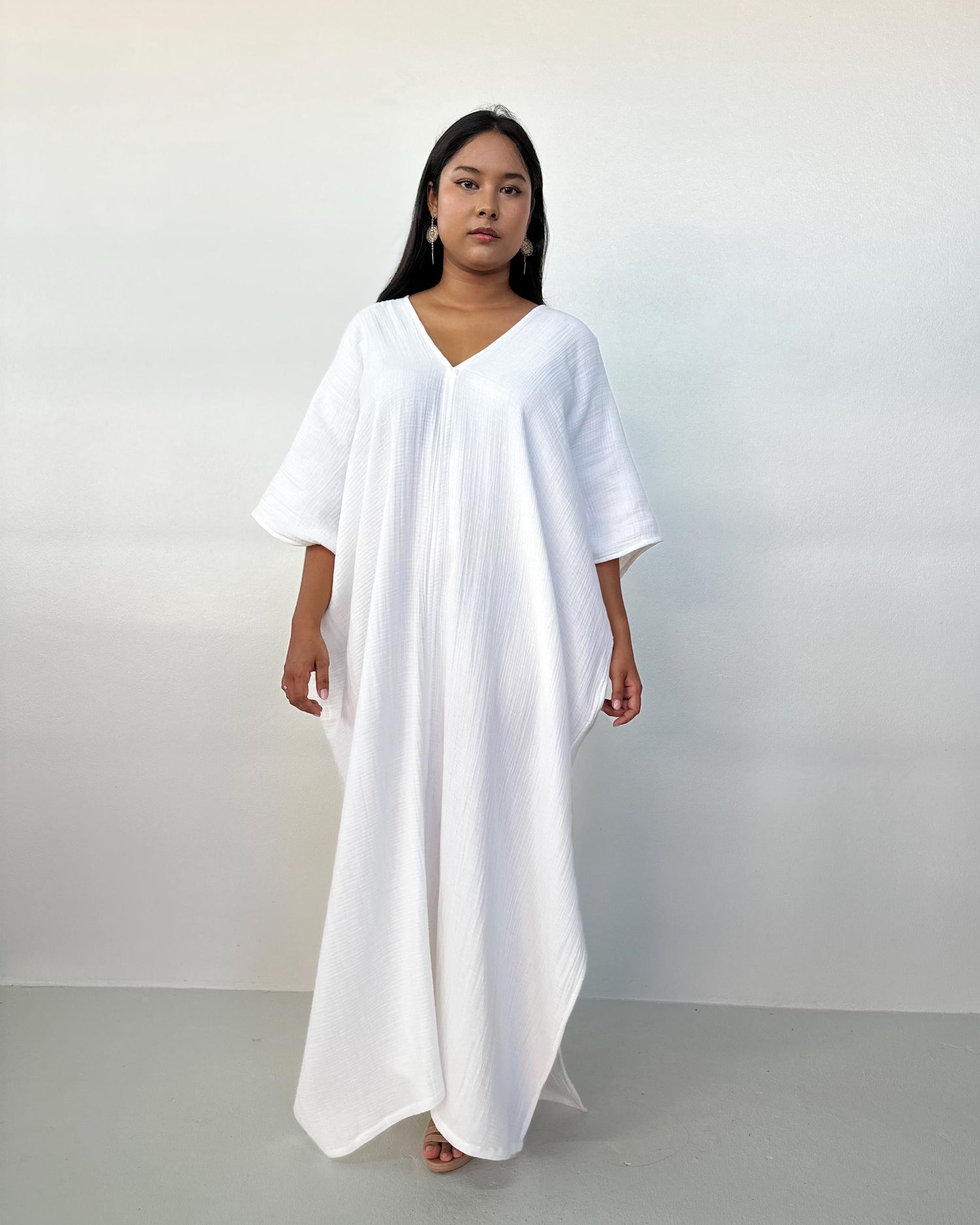 Woman wearing a white dress against a plain background