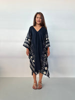 Woman wearing a black tie-dye dress against a white background