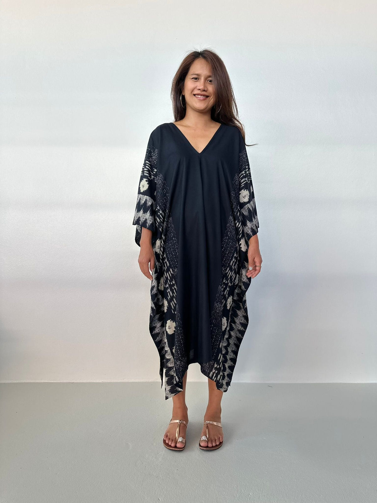 Woman wearing a dark blue dress with floral patterns on a white background