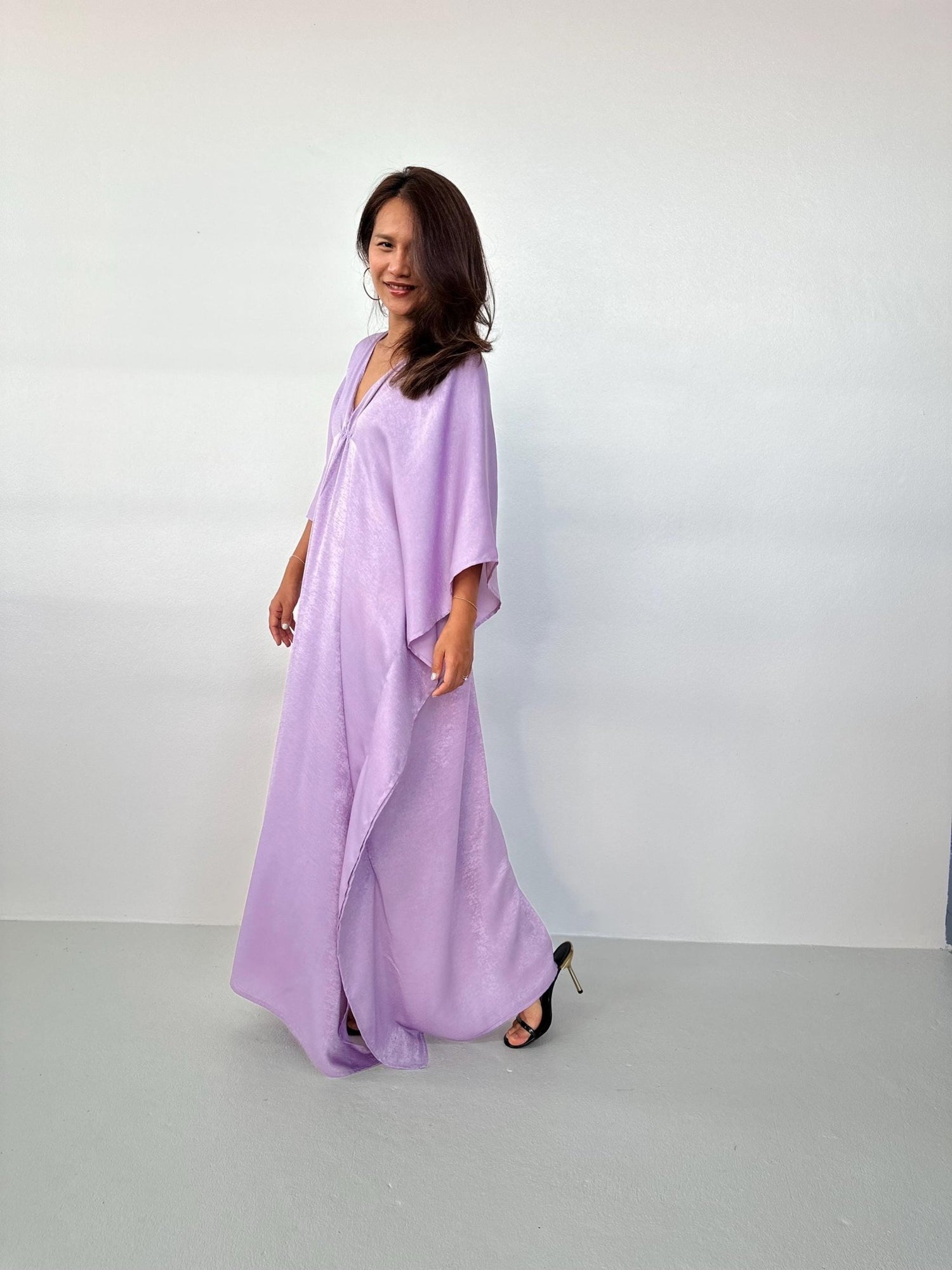 Woman wearing a light purple dress against a white background