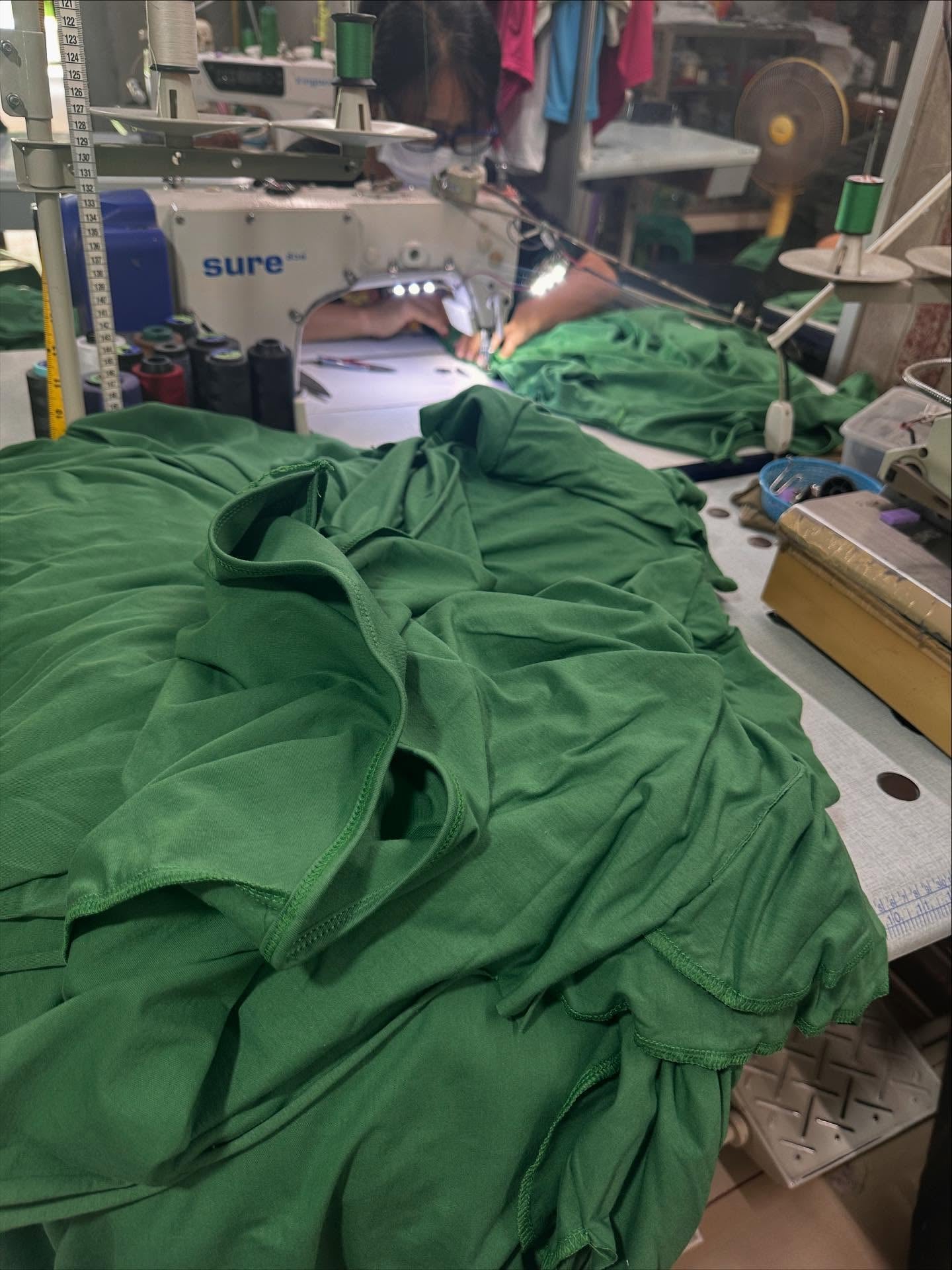 Stack of green fabric in a sewing workshop.